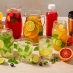 Refreshing summer drinks in glass jars and pitchers, including citrus-infused water, herbal lemonade, iced tea, and fruit mocktails—perfect for hydrating at picnics, garden parties, and warm-weather gatherings.