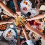 Overhead view of friends sharing tapas and finger foods around a vibrant picnic table—perfect for group gatherings, outdoor feasts, and Mediterranean-style picnic party ideas.